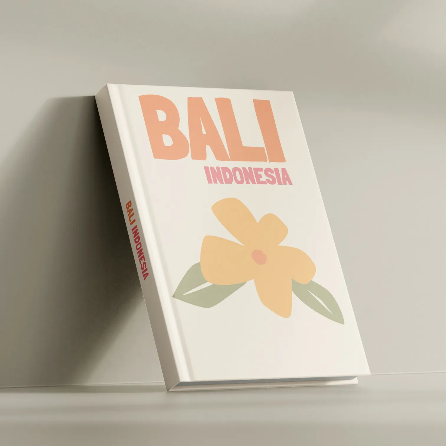 A Kito travel book standing on end, its cover reading BALI INDONESIA above a drawn frangipani flower.