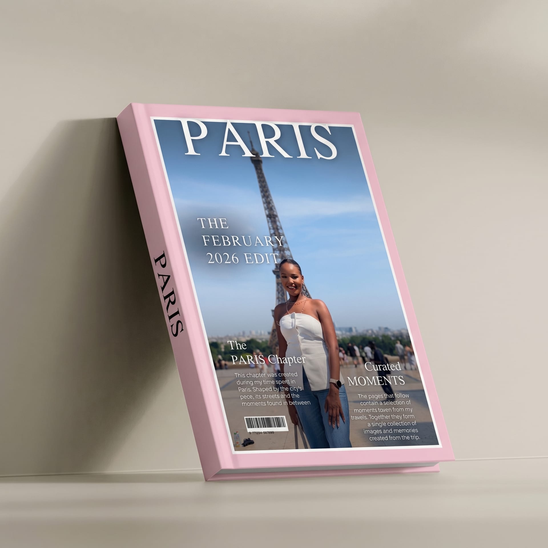 A Kito Magazine Edition book standing against a wall: a pink Paris cover with the traveller photographed in front of the Eiffel Tower, cover lines and a barcode set like a magazine.