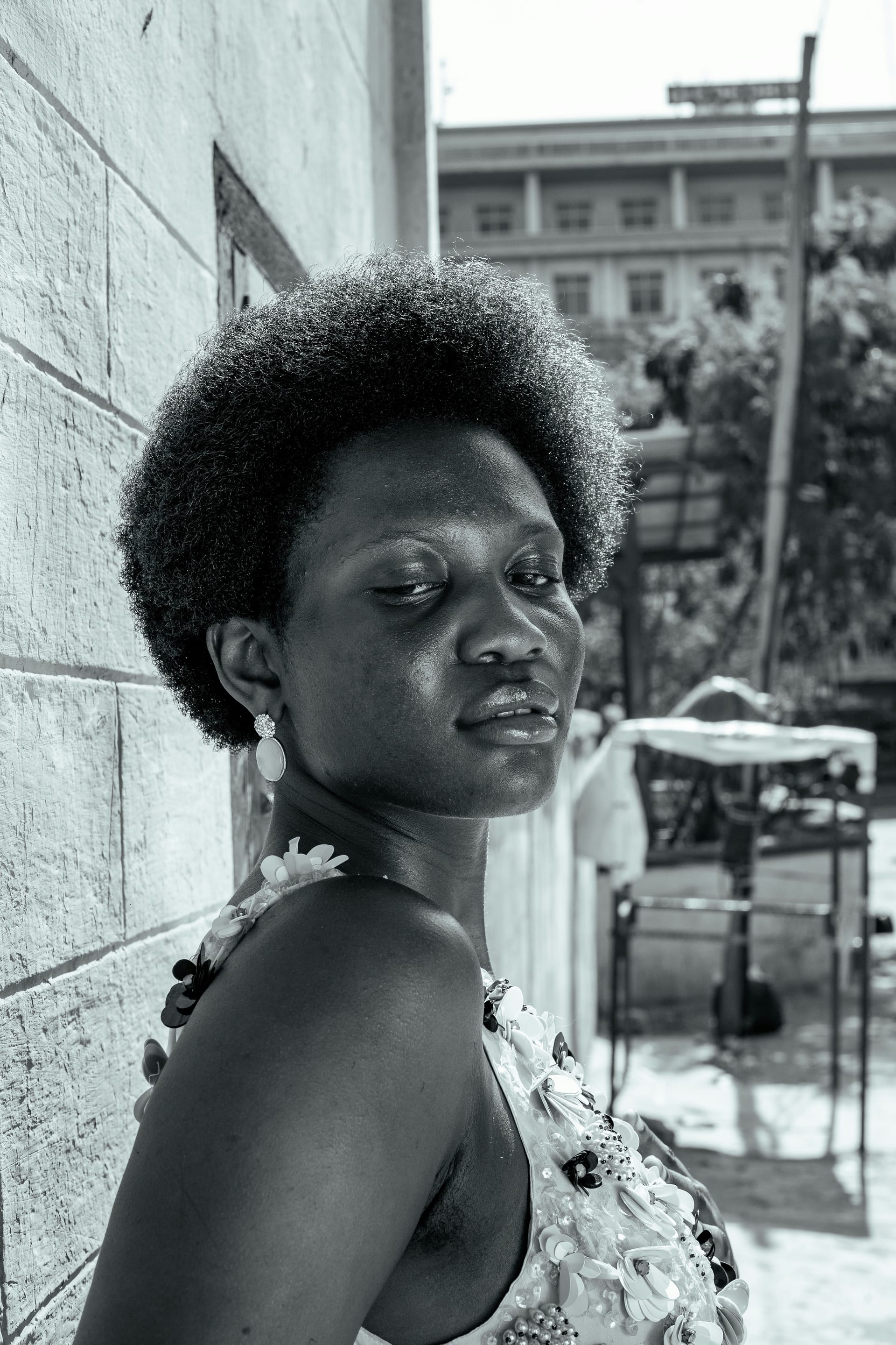 Portrait of Christine Adhiambo, laughing in backlit evening sun.